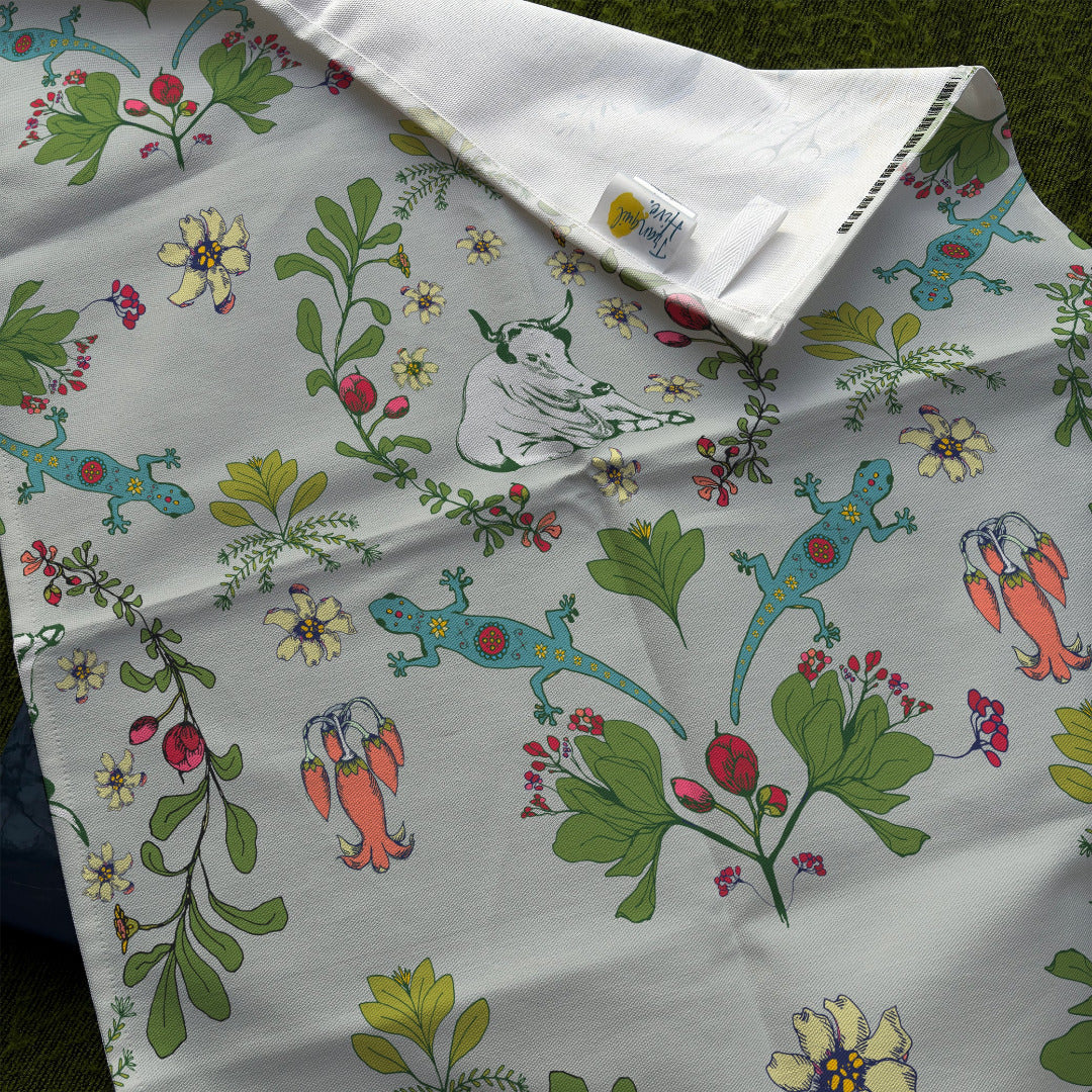 Meadow Tapestry tea towel folded over to show leap and TranquilHive Logo.