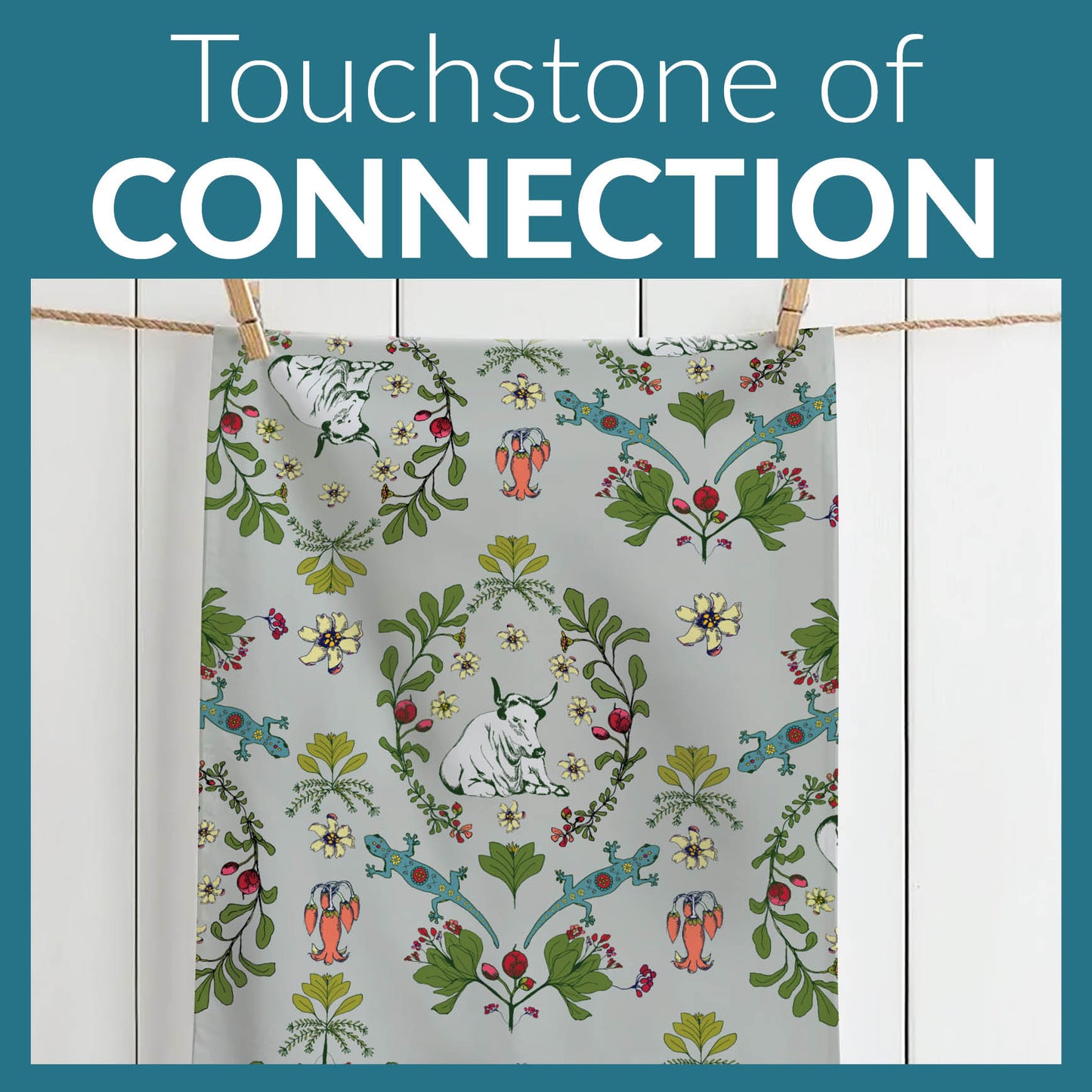 Meadow Tapestry Tea towel on line with nature-themed pattern hanging on a line against a white wall, with 'Touchstone of Connection' text above.