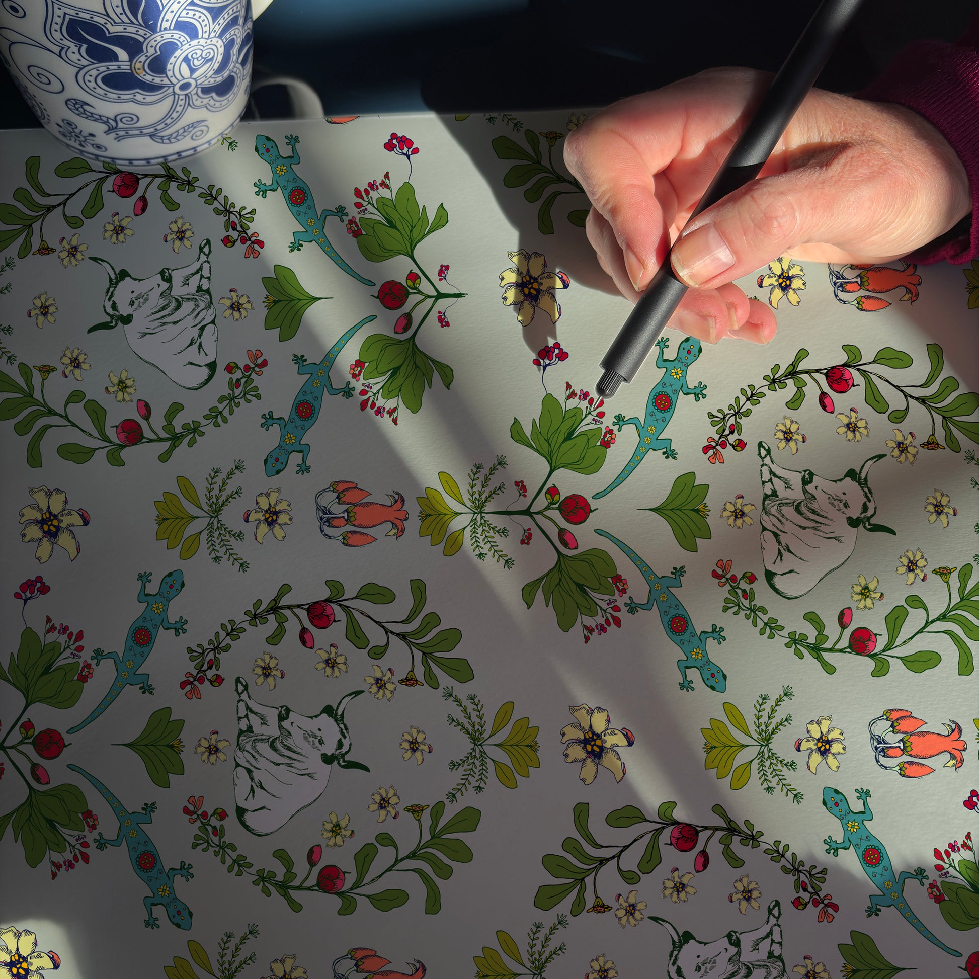 Using pen and ink to outline the delicate detains of the flowers cows and geckos