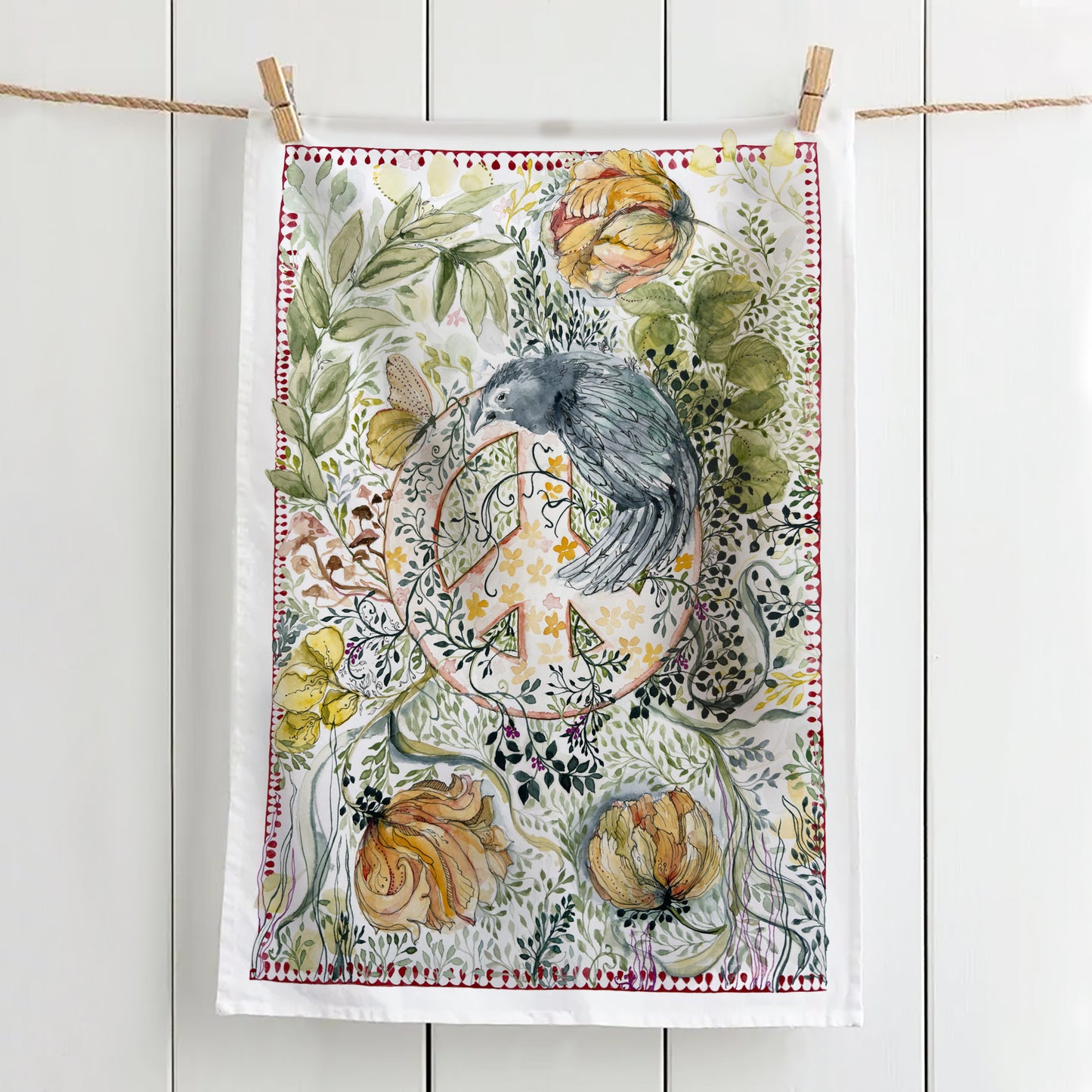 Tea towel with crow watching over a peace sign hanging on a line with pegs